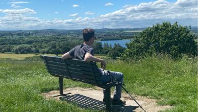 Andy resting on a bench in the countryside