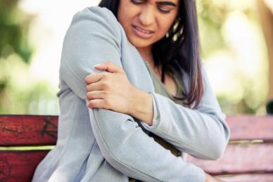 woman holding arm in pain