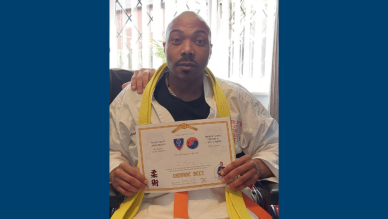 Christopher showing his jiu-jitsu grading certificate