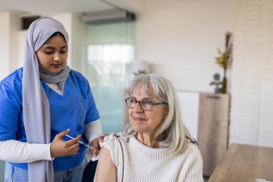 Older woman being given flu vaccine