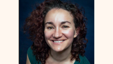 lade with dark curly hair smiling