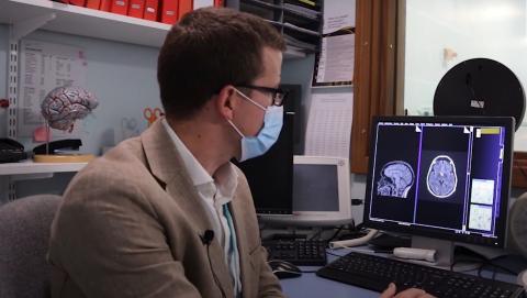 Dr with MRI scan on computer screen