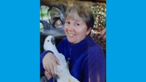 Mary smiling holding a cockatoo