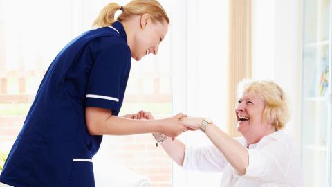 Nurse helping lady stand