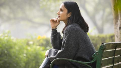 Thoughtful woman sitting on bench at park