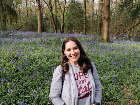 Carla King in front of a field of bluebells