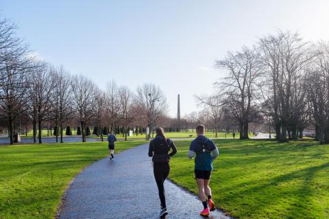 runners facing away from the camera on a path in Glasgow Green