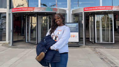 Natalie standing outside doors at ECTRIMS