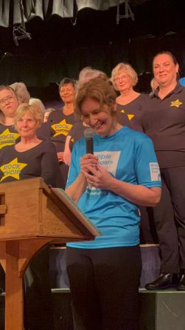 Sally giving a speech during the Rock Choir concert