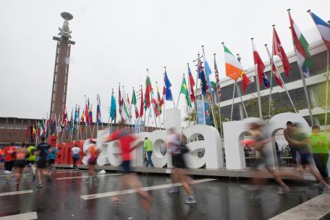 Runners in front of the Amsterdam sign in Amsterdam, the Netherlands