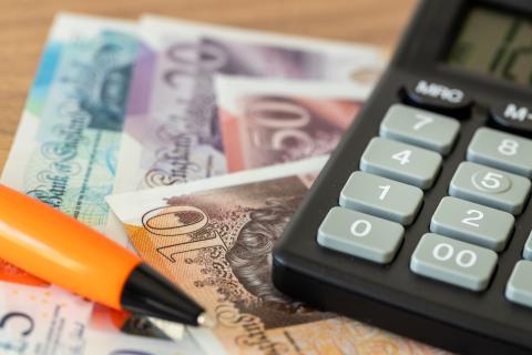 British pound notes, pen and calculator