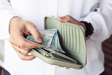 Person putting cash in purse