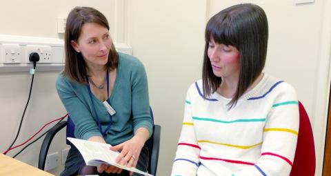Health professional sharing MS Trust book with person with MS