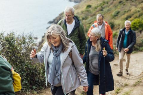 group of people walking a coastal path