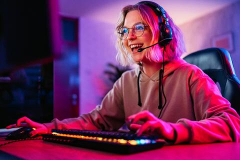 Woman playing a video game on her desktop pc at home.