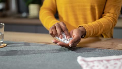 Person taking tablets out of blister pack