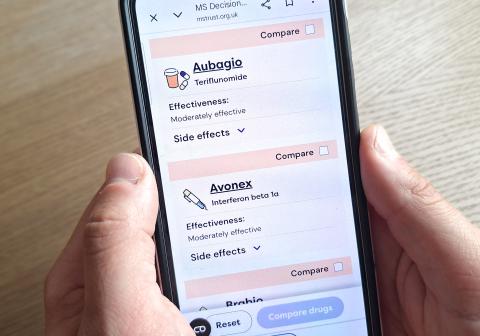 Person holding smartphone displaying MS Decisions