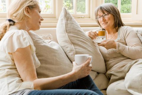 two middle-aged women talking while drinking tea