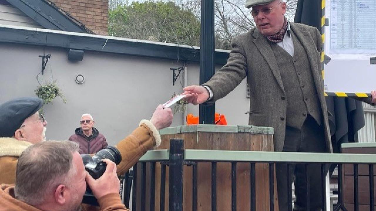 man photographed in flat cap, tweed waistcoat and jacket