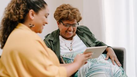 Two women viewing tablet
